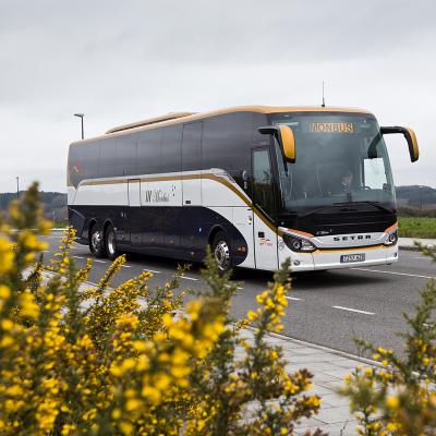 Autobús de Monbus circulando por unha estrada nacional