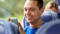 Guy checks his phone on a bus