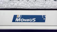 Lateral de un autobús Monbus cubierto de nieve
