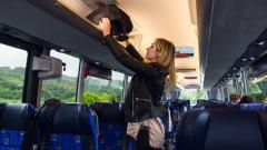 Traveller puts her luggage on the bus of Monbus