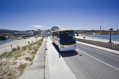 Autobús de Monbus circulant per una carretera de la costa