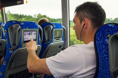Viaxeiro usando as pantallas multimedia dos buses de Monbus