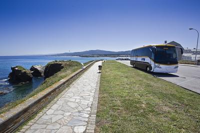 Autobús de Monbus estacionado xunto ao mar