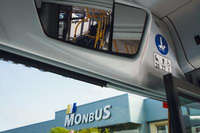 Interior of a Monbus urban bus reflected in rear-view mirror