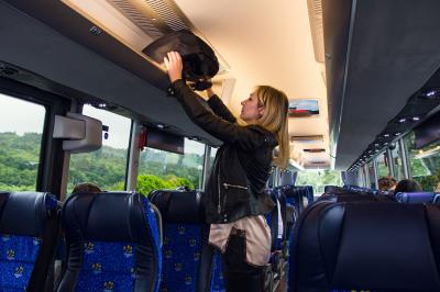 Une voyageuse met son équipage dans un autobus de Monbus