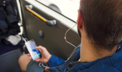 Usuario de Monbus utiliza o seu teléfono móbil durante unha viaxe